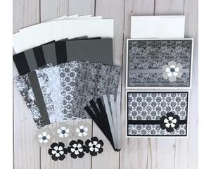 A card making to kit with black and white scrapbook paper, cardstock, flower embellishments, ribbons and cards and envelopes.